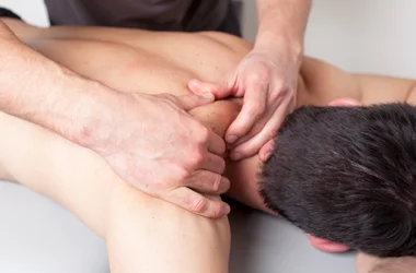A massage therapist performing a shoulder massage